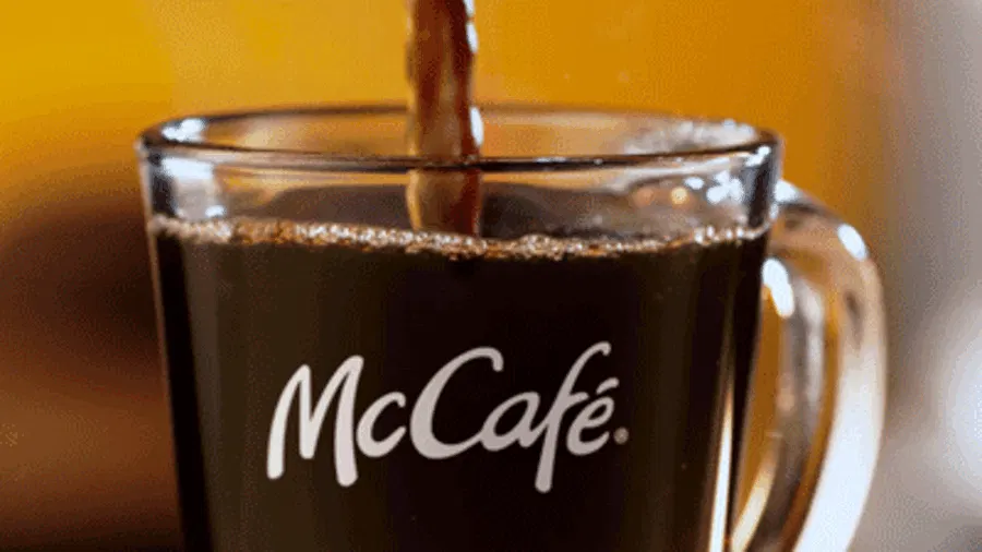 Se muestra un vaso que se va rellenando con cafe y tiene el logo de McCafé