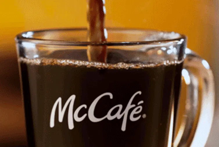 Se muestra un vaso que se va rellenando con cafe y tiene el logo de McCafé