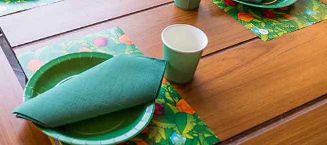 Una mesa de madera con un utensilios de plástico verdes